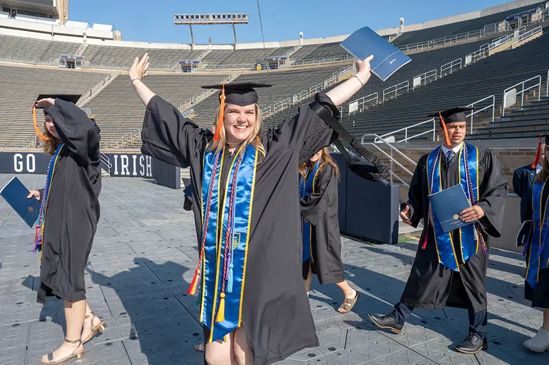 College of Engineering graduate Mary Kate McGuirk celebrates as she enters Notre Dame Stadium for the 2024 Commencement ceremony.