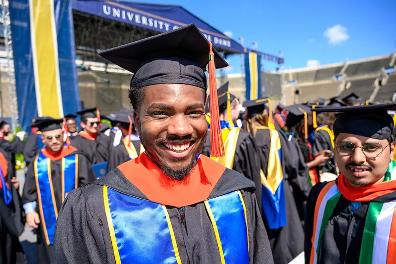 Grad school graduate smiles after the commencement ceremony.