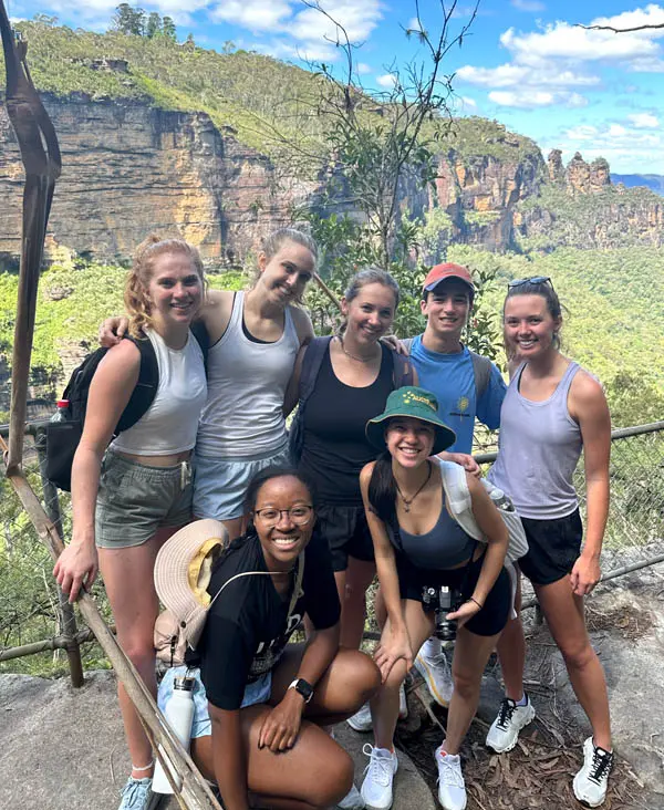 Savannah Carr and a group of friends stand if front of beautiful scenery.