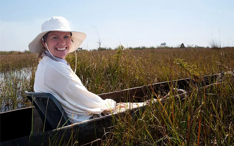 Grace Clinton sits in a canoe in the river.