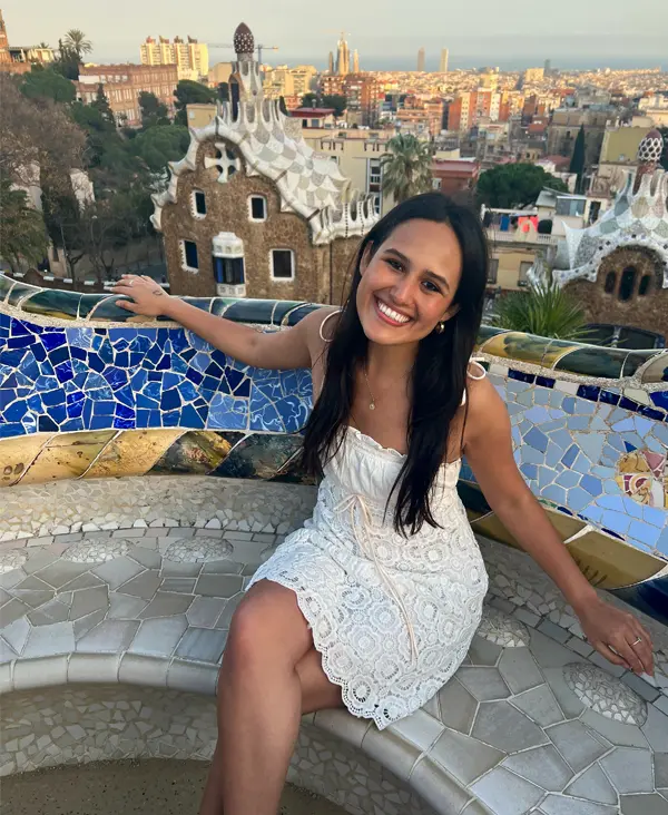 Elizabeth Gonzalez sits on a blue mosaic bench in Barcelona.