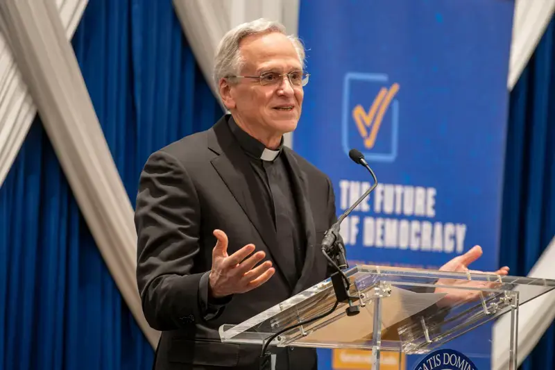 Portrait of Rev. John I. Jenkins standing at a podium.