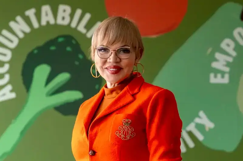 Portrait of Claire Babineaux-Fontenot wearing an orange blazer