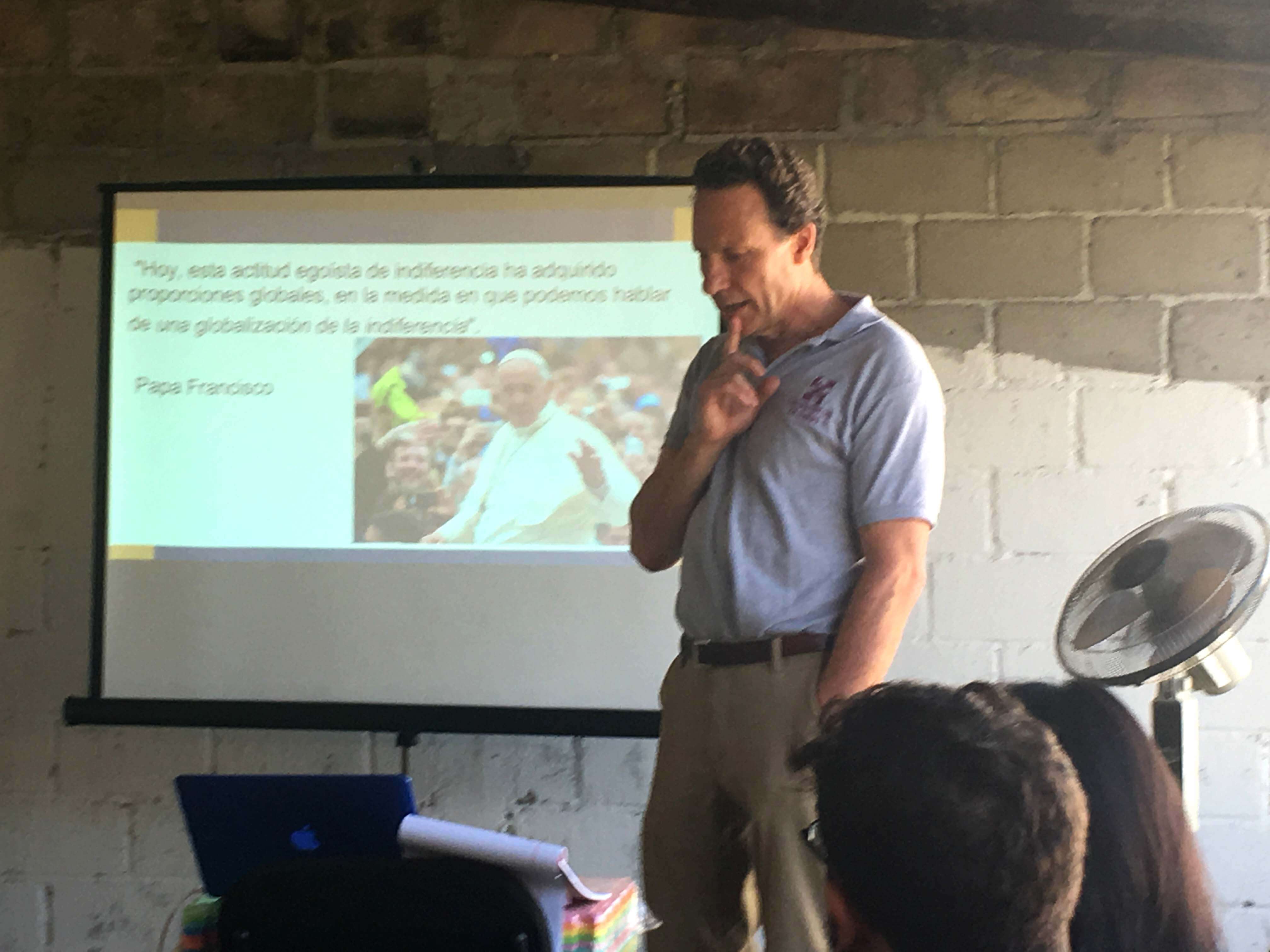 Associate professor Steve Reifenberg gives a presentation in front of a Powerpoint projected on a screen.