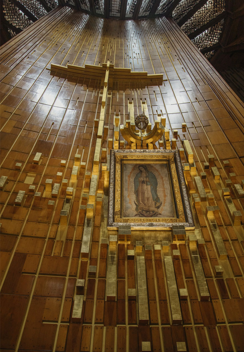 Portrait of Our Lady of Guadalupe against a tall wood wall