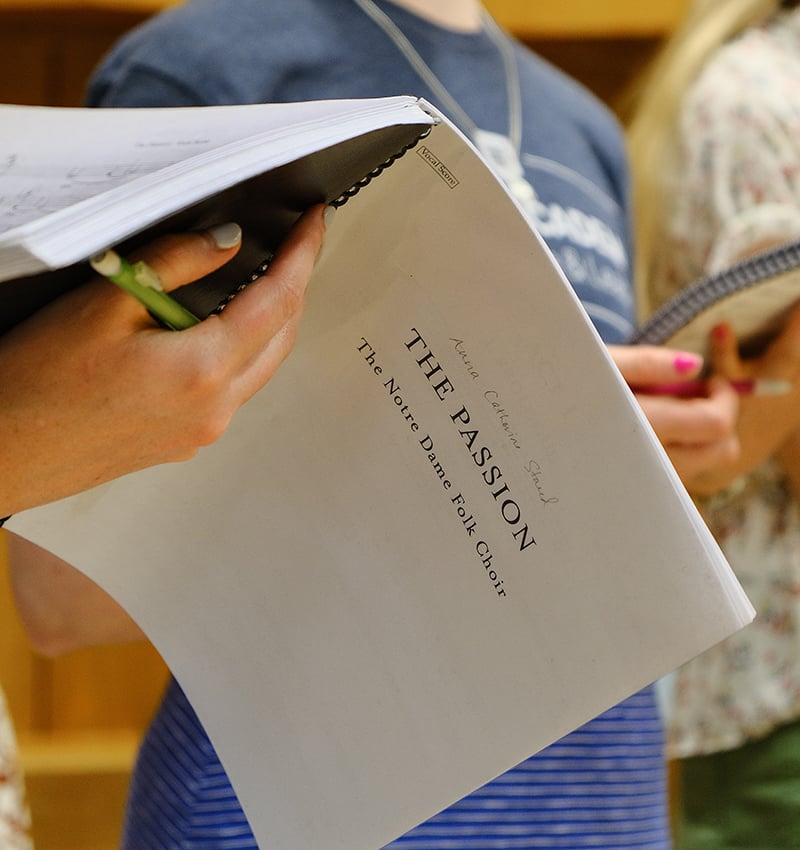 A vocalist holding a book of sheet music