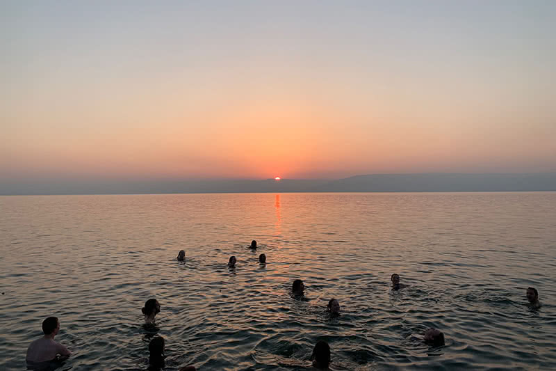 Students swimming during sunset