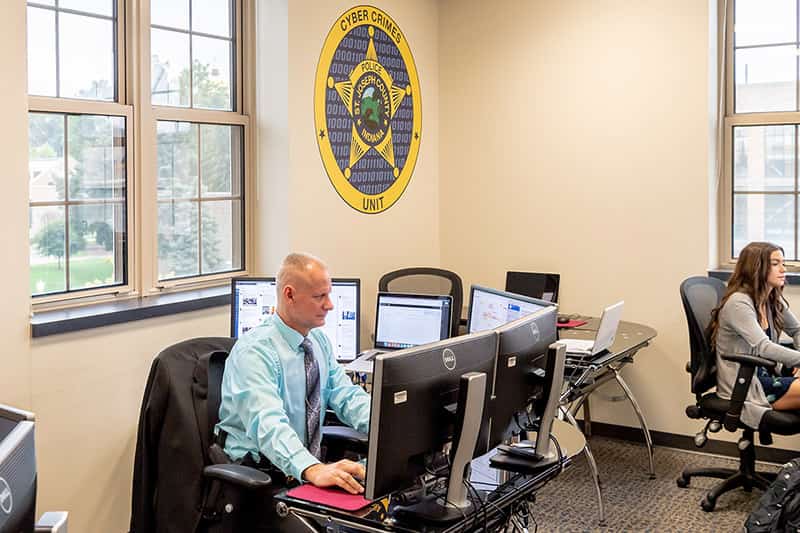 A man sits at a desk working on his computer.