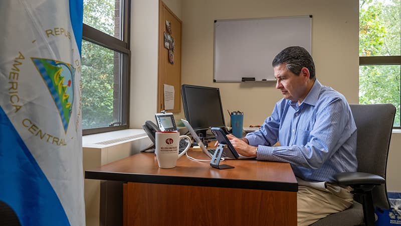 Kellogg Fellow Juan Sebastian Chamorro sits at his desk working on his book in his office at the Hesburgh Center.