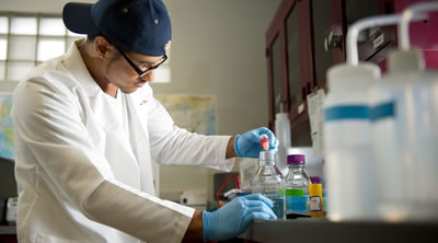 Senior Holden Lombard in a lab pouring liquid into a jar