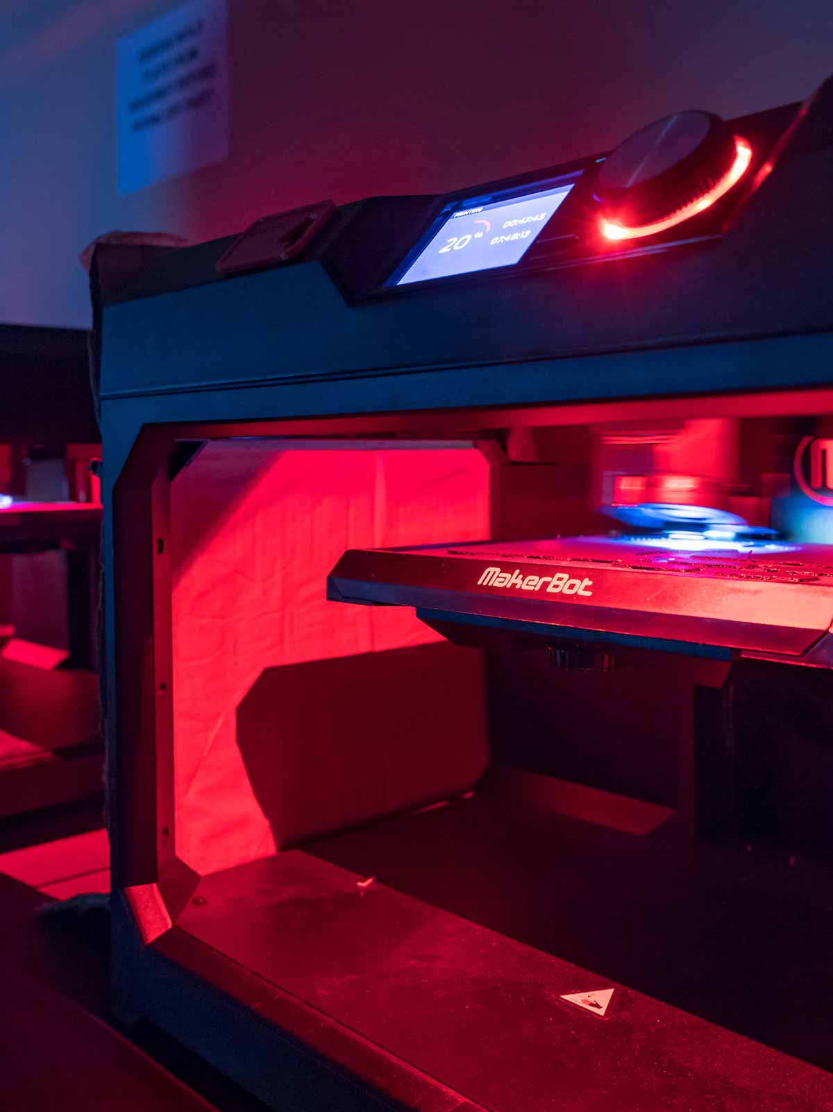 3D printers glow a pinkish red color in Fitzpatrick Hall of Engineering.