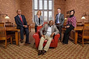 Five lawyers pose in the library