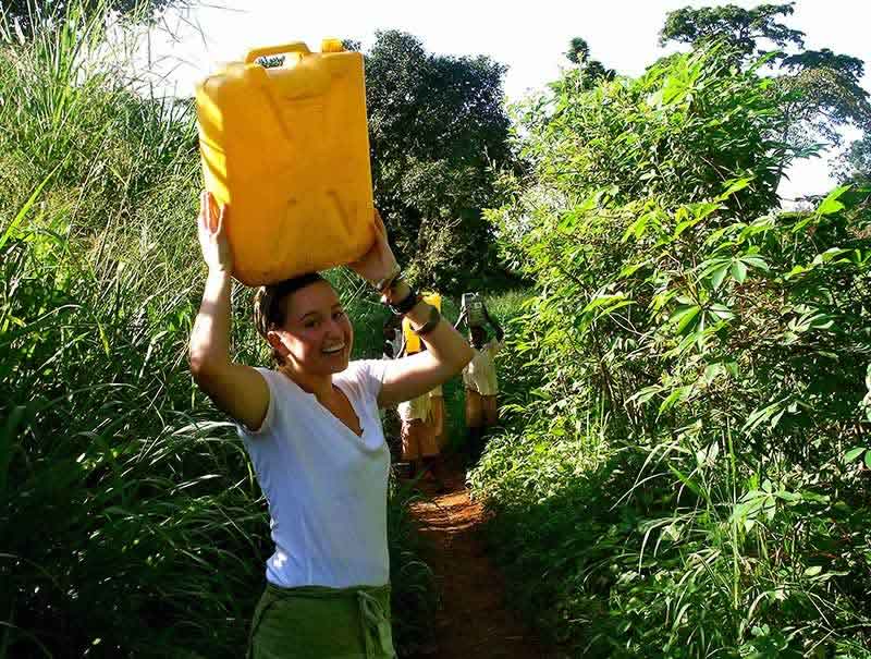 Emily carrying a jerrycan to the river to get water.