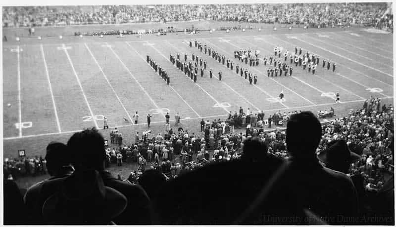 Football game scene, marching band on the field.