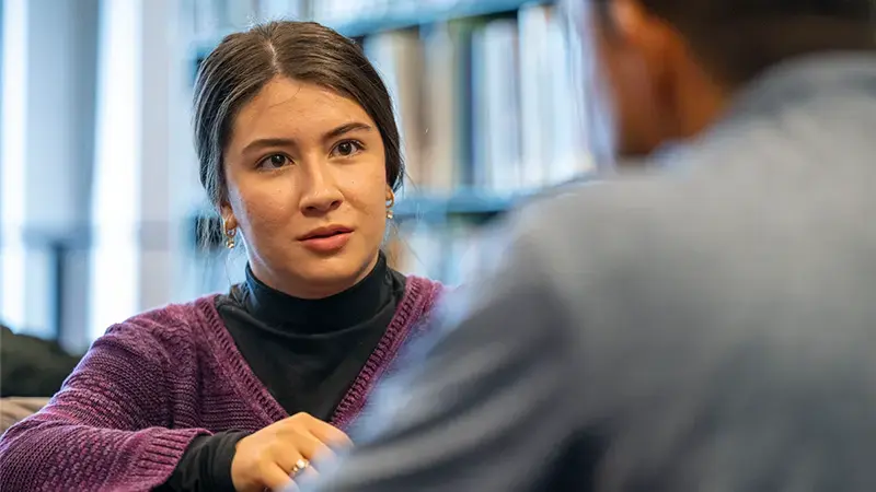 A close up of Cassandra Bustillos as she listens to Enrique Arista Salgado.