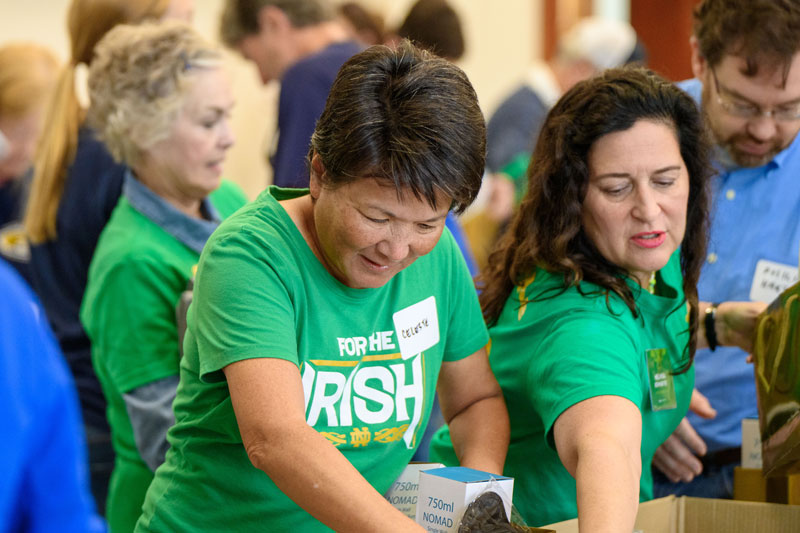 Two women wearing green Notre Dame shirts volunteer at Mater Misericordiae University Hospital Dublin.