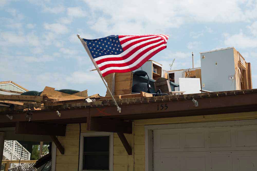 An American flag flys on a house that was damaged the hurrican.
