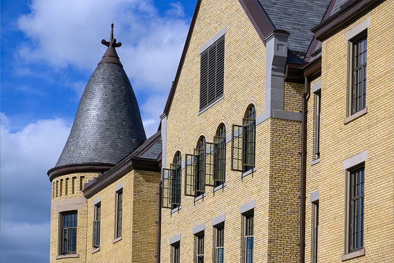 Yellow bricks of Sorin Hall are dotted with windows. The roof is lined with greyish-green clay tiles.