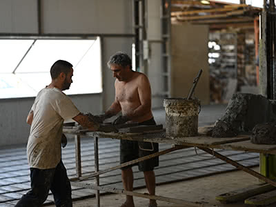 Clay workers forming bricks with clay that has been locally harvested