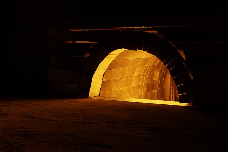 A glowing kiln fire as viewed from the darker outside.