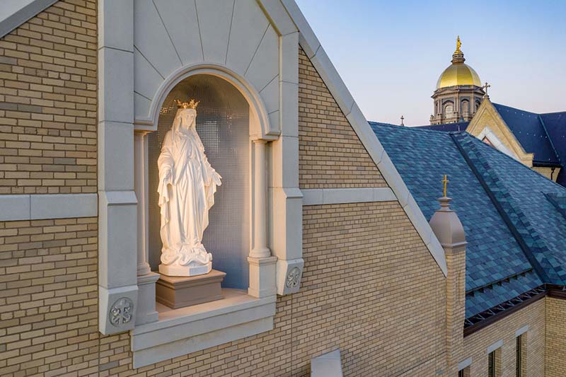 Statue of Mary in an alcove of the exterior. The Dome is in the background.