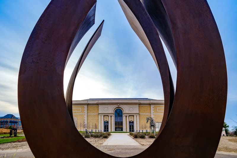 The exterior of Raclin Murphy Museaum of Art peaks through a large horseshoe-shaped sculpture on the east entrance.