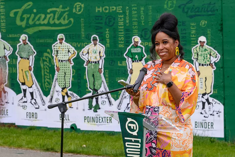 Lenisha Lipley speaks at the podium during a gatheringabout Alonzo Poindexter's legacy of service.