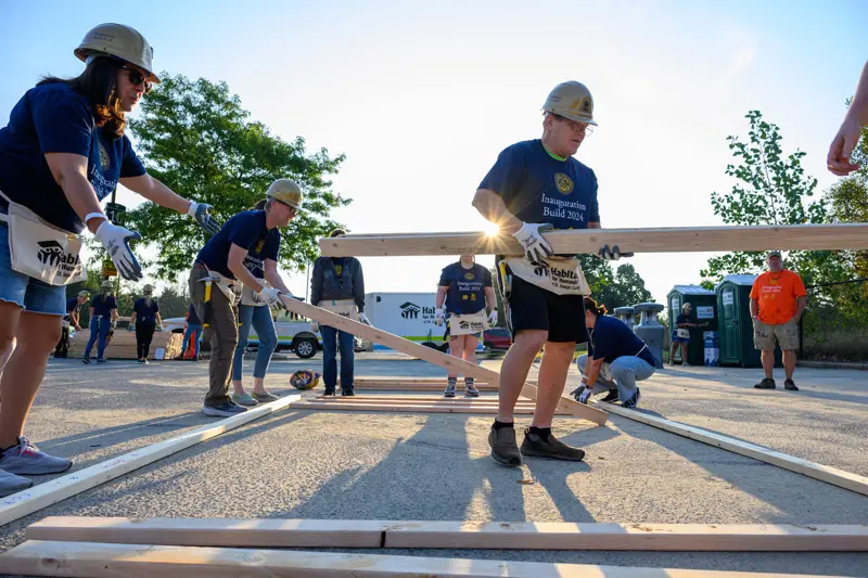 A group of workers help to build the frame of a Habitat for Humanity house.