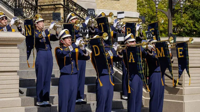 Notre Dame Marching Band playing trumpets during the Inauguration ceremony on the steps of the main building on campus.
