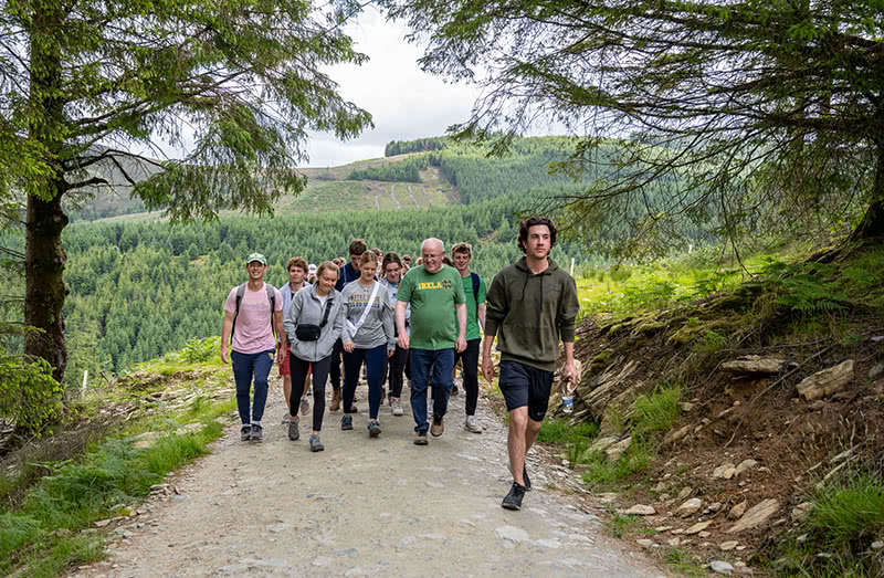 Kevin Whelan walking the trails of Glendalough with students