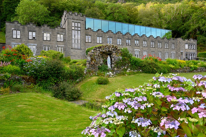 Flowers grow in the front lawn of Kylemore Abbey