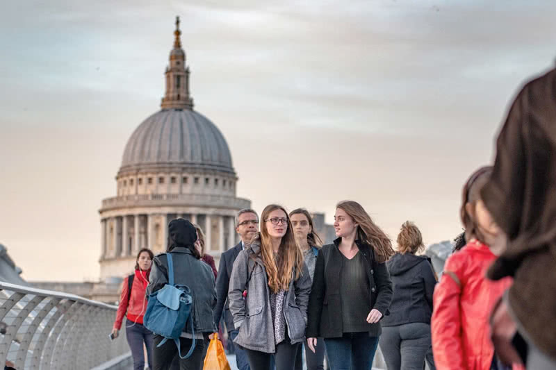 Close up of Notre Dame students walking in London with a domed building in the background