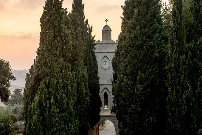 A row of cypress trees leads up to Tantur.