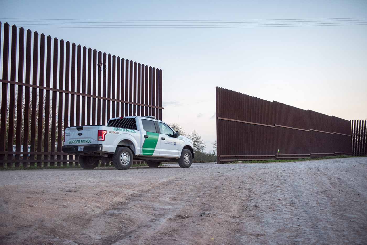 A border patrol vehicle driving along the U.S.-Mexican border.