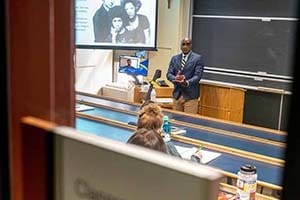 A professor teaches before a class in a classroom.