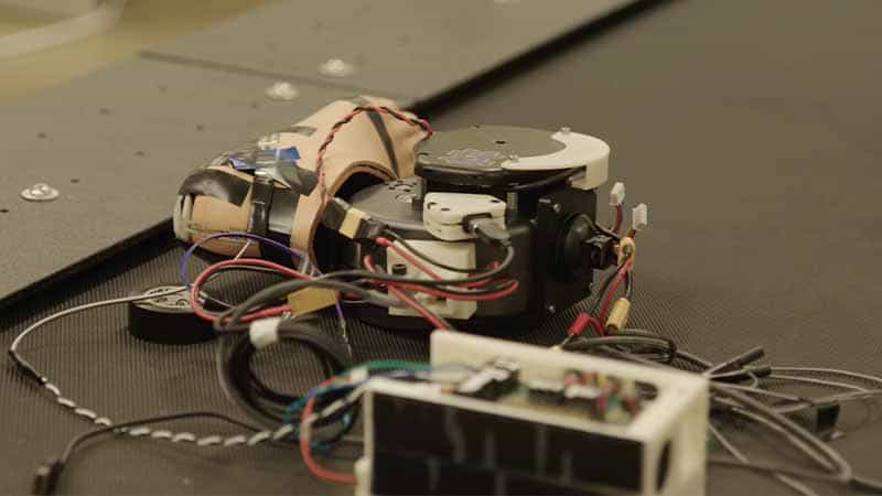 A prosthetic foot attached to a powered prosthetic ankle, with a Notre Dame Monogram sticker, surrounded by wires.