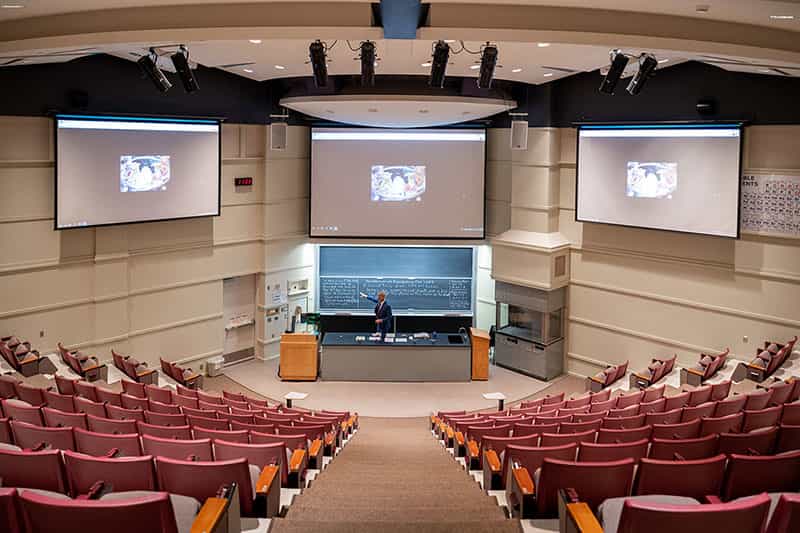 In an empty classroom, a professor teaches via remotre learning.