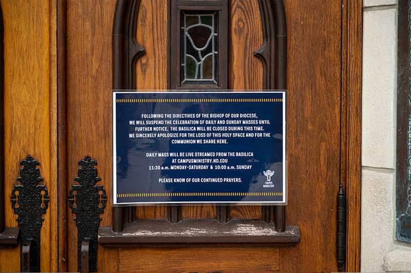 A sign taped to the doors of the Basilica of the Sacred Heart.