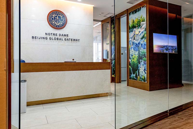 The inside of the Global Gateway, with a sign that reads Notre Dame Beijing Global Gateway and large photos of Main Building.