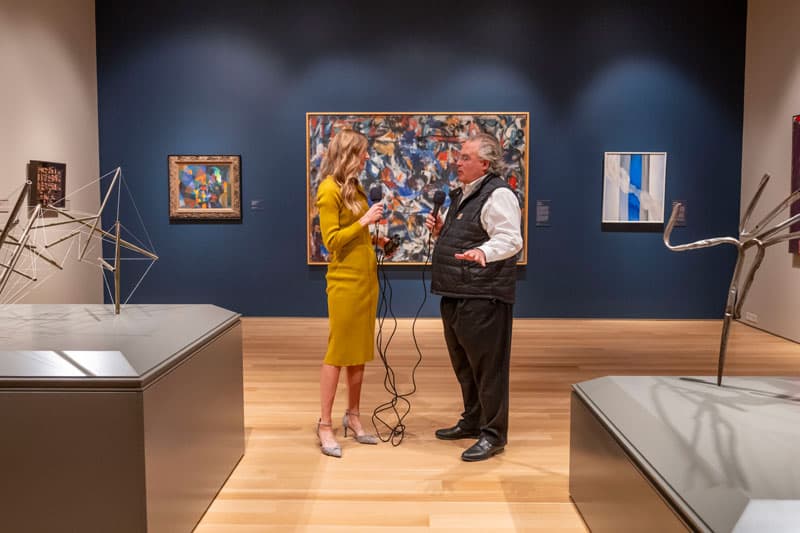 Jenna Liberto interviews Joe Becherer in front of a painting in the Raclin Murphy Museum of Art