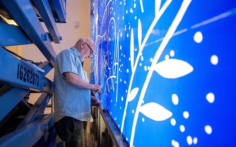 A worker assembles a display for an exhibit at the Raclin Murphy Art Museum