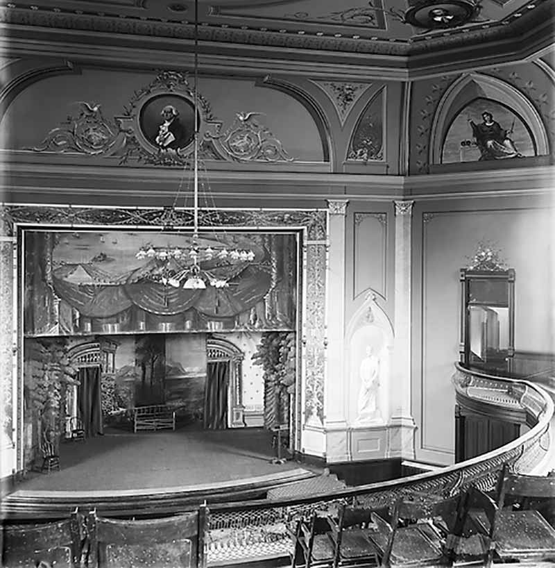 Washington Hall interior, c1890s. A painting of Washington is hung above the stage.