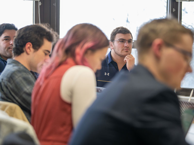 Andrew attends class in Flanner Hall with a window behind him.