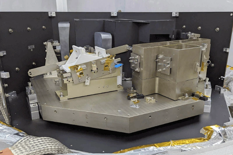 Side view of a spectrograph with metal machine parts and other complex workings