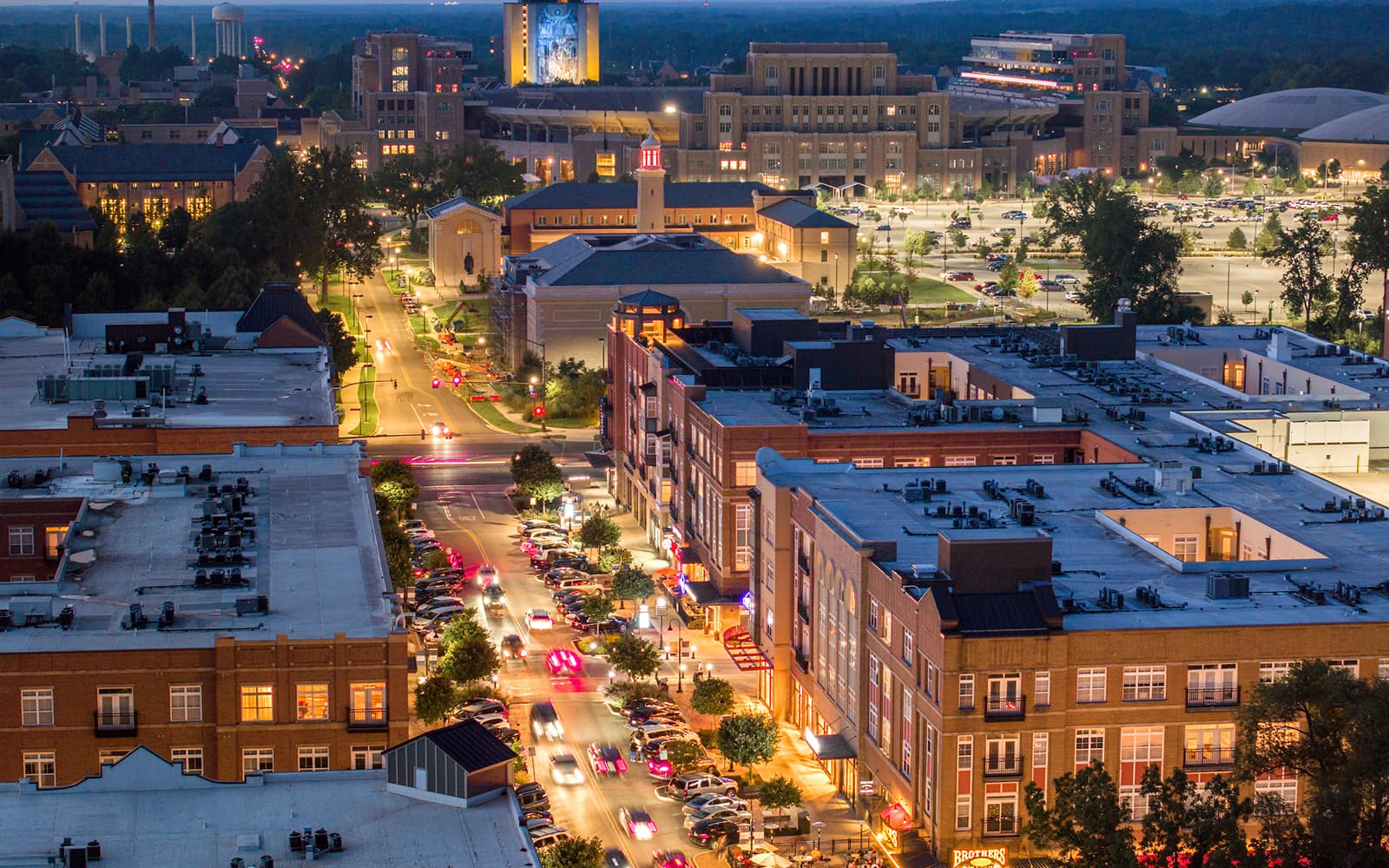 Eddy Street at dusk, shot from above with the Hesburgh Library and the Word of Life Mural—more commonly known as Touchdown Jesus—lit up in the background.