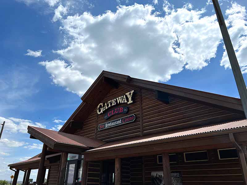 A log building with a sign that reads 'Gateway Club - Bar, Restaurants, Casino.