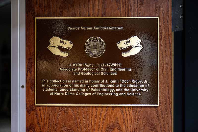 A plaque on a door that reads 'J. Keith Rigby, Jr. (1947-2011) - Associate Professor of Civil Engineering and Geological Sciences - This collection is named in honor of J. Keith 'Doc' Rigby Jr., in appreciation of his many contributions to the education of students, understanding Paleontology, and the University of Notre Dame Colleges of Engineering and Science.'