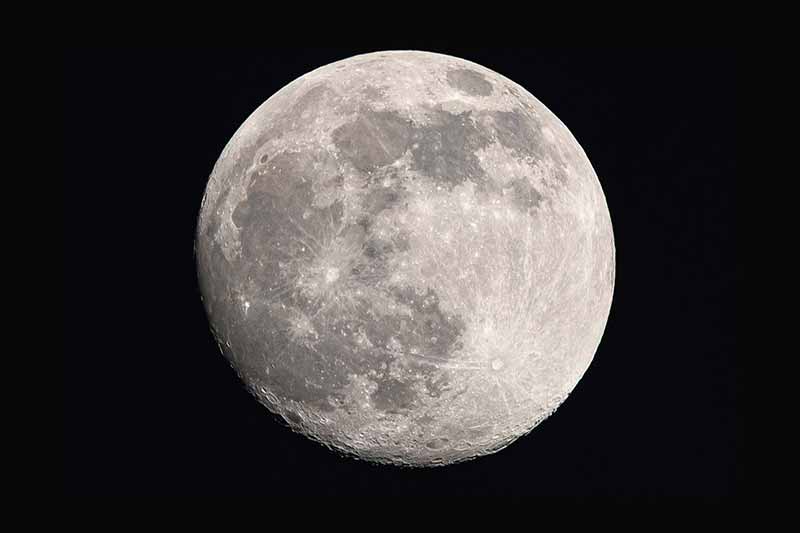  close up, textured shot of the Moon, the background is pitch black.