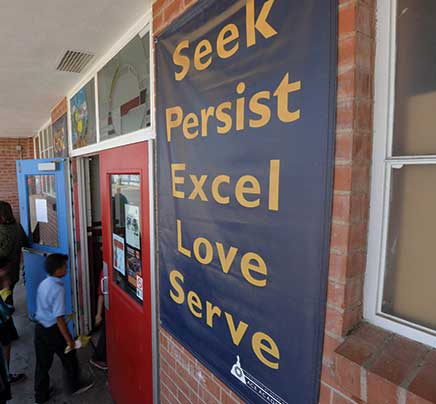 Blue banner with the words Seek, Persist, Excel, Love, and Serve