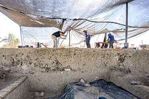 Two students dig at a excavation site.